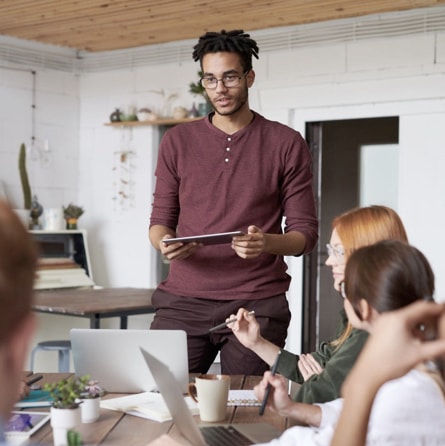 Man holding a tablet conducting a meeting