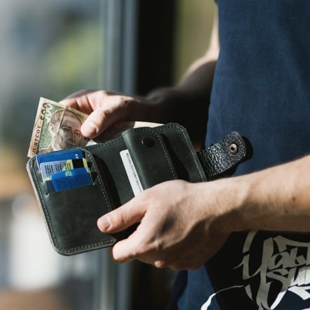 image of man taking money out of his wallet